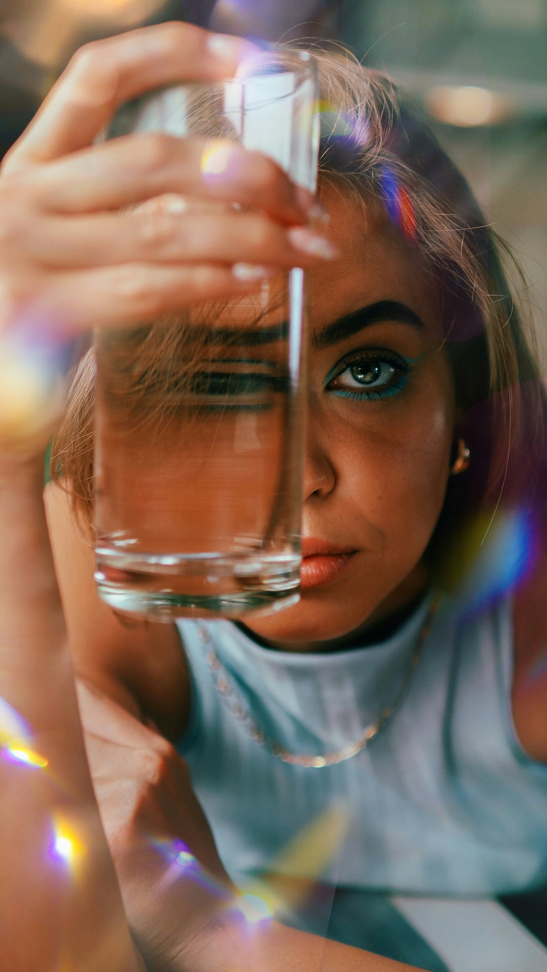 woman in white crew neck t-shirt holding clear drinking glass