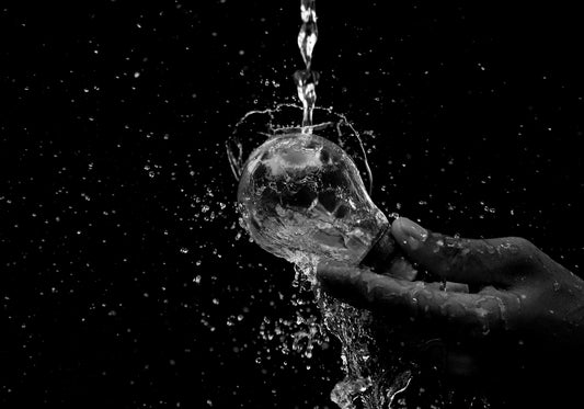 A person holding a glass of water in their hand