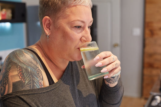 Woman enjoys a drink from a glass.